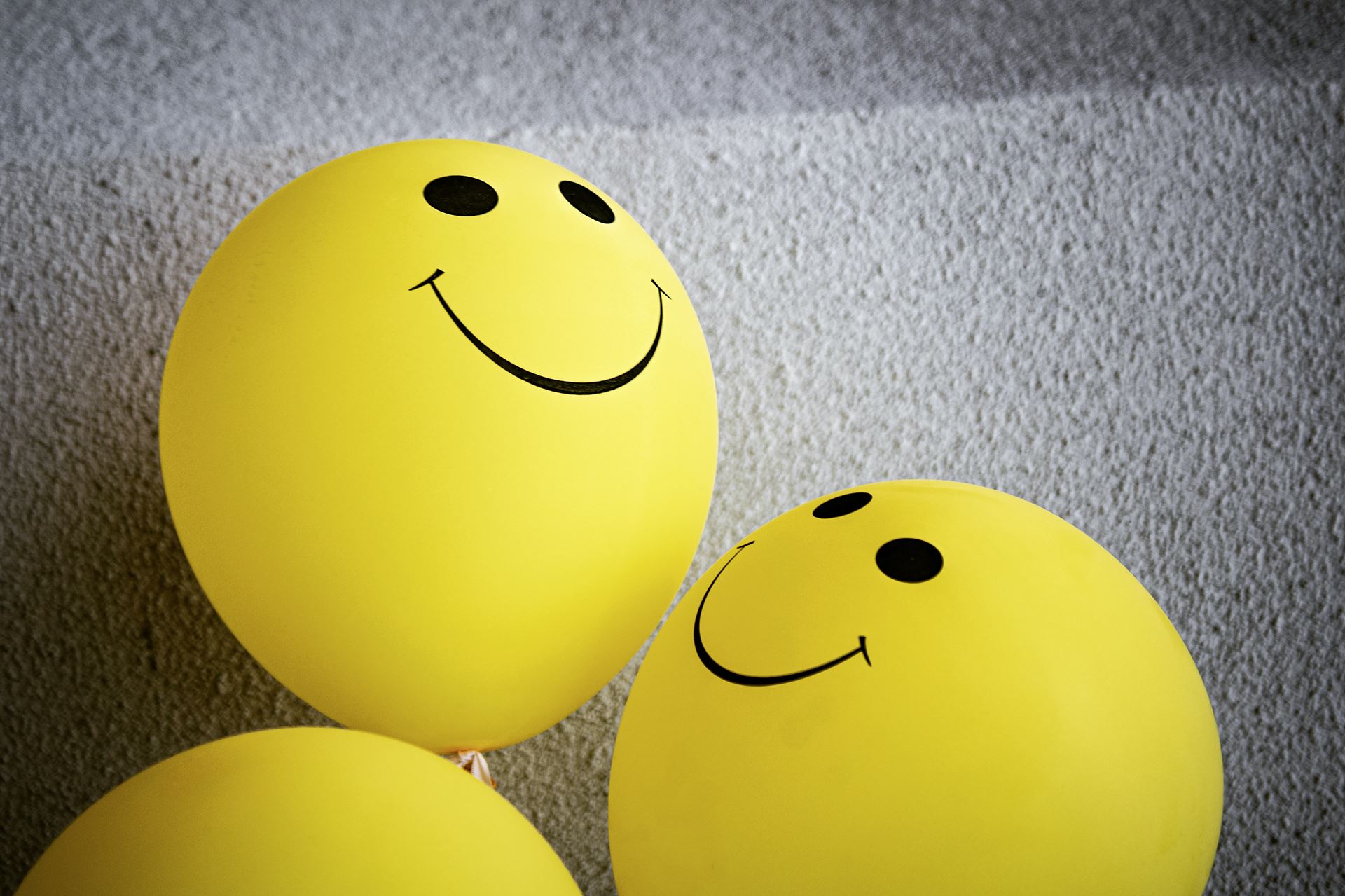 a selection of yellow balls with smiley faces on them