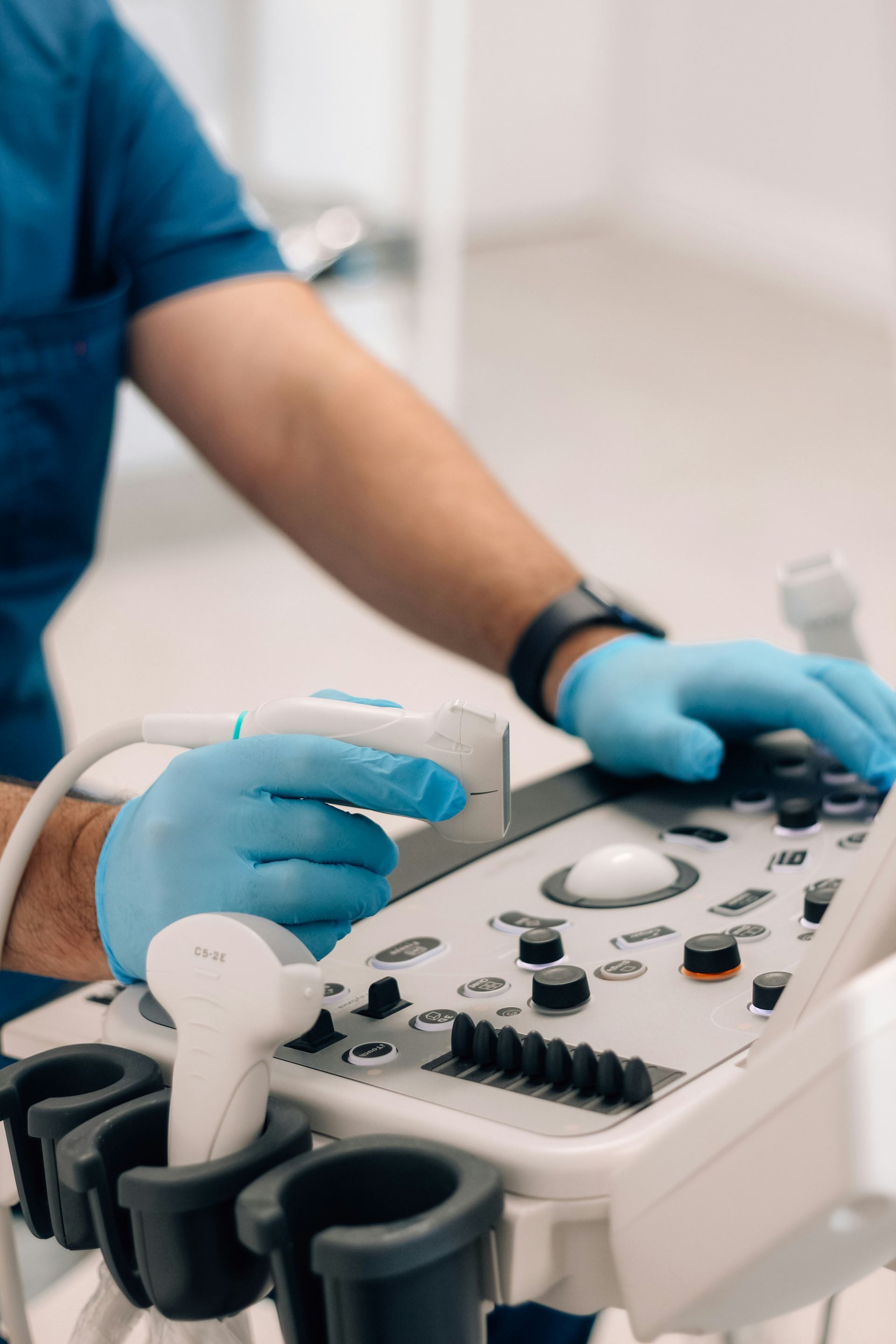 A medical professional wearning blue gloves and performing an ultrasound
