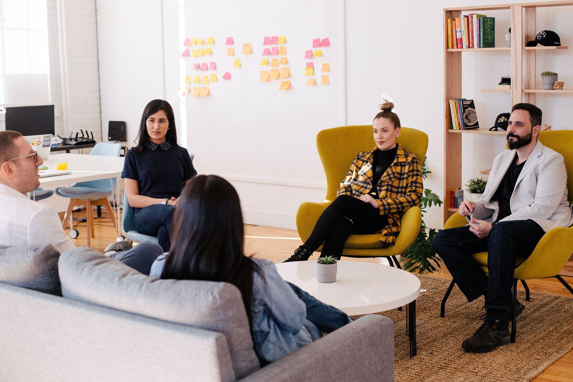 A group of people sitting on chairs in a room talking