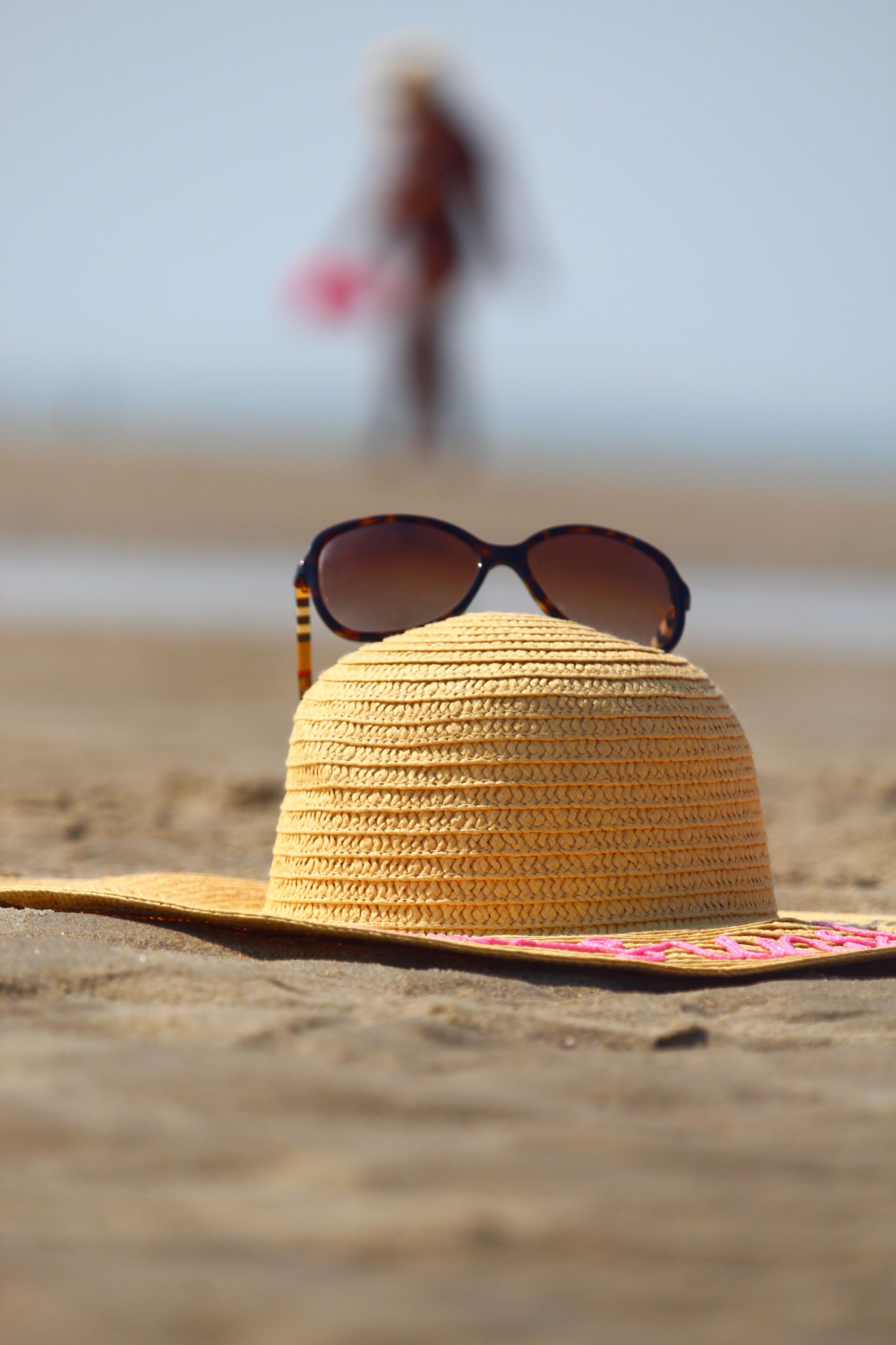 a sunhat and sunglasses on the beach