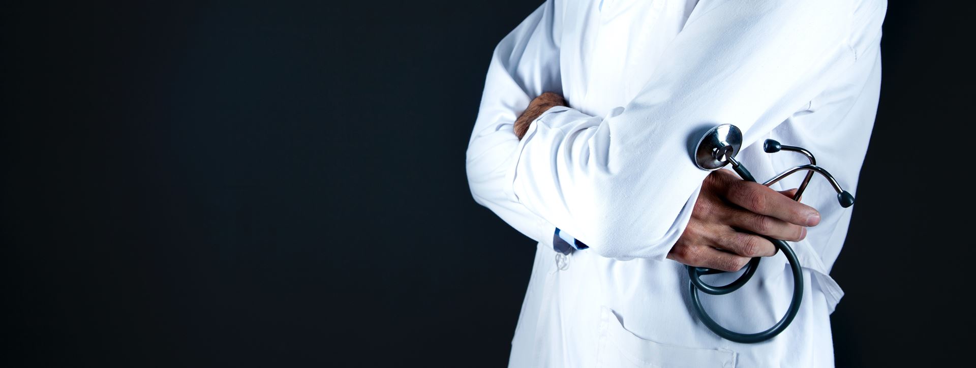A person in a white coat holding a stethoscope