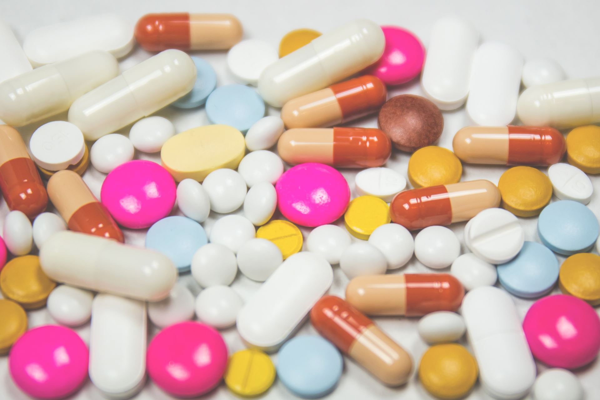 a selection of different coloured medication tablets