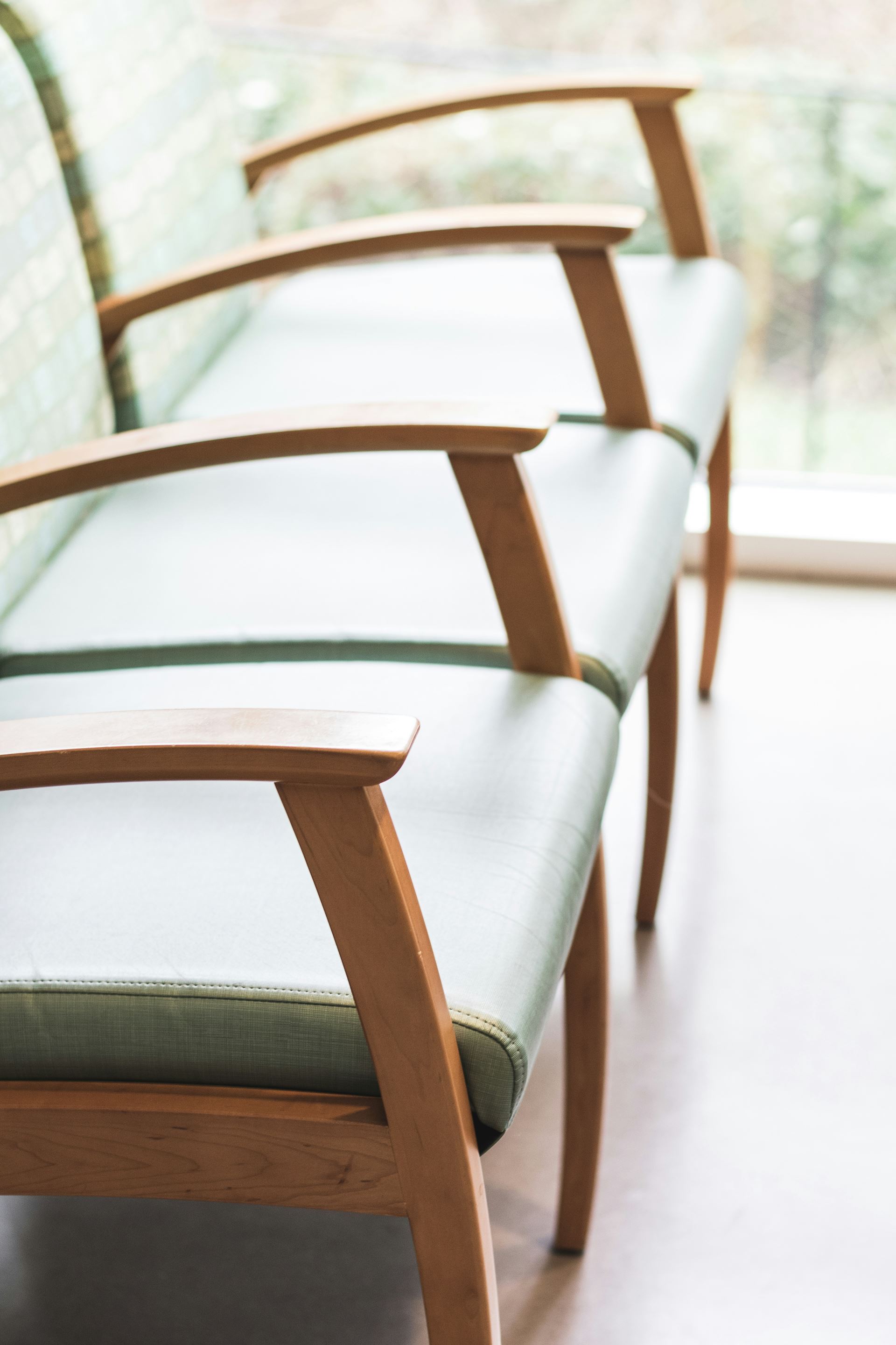 A row of chairs with arms in a waiting room